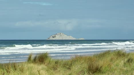 hawkes bay with distant te motu-o-kura bare island on shore of new zealand