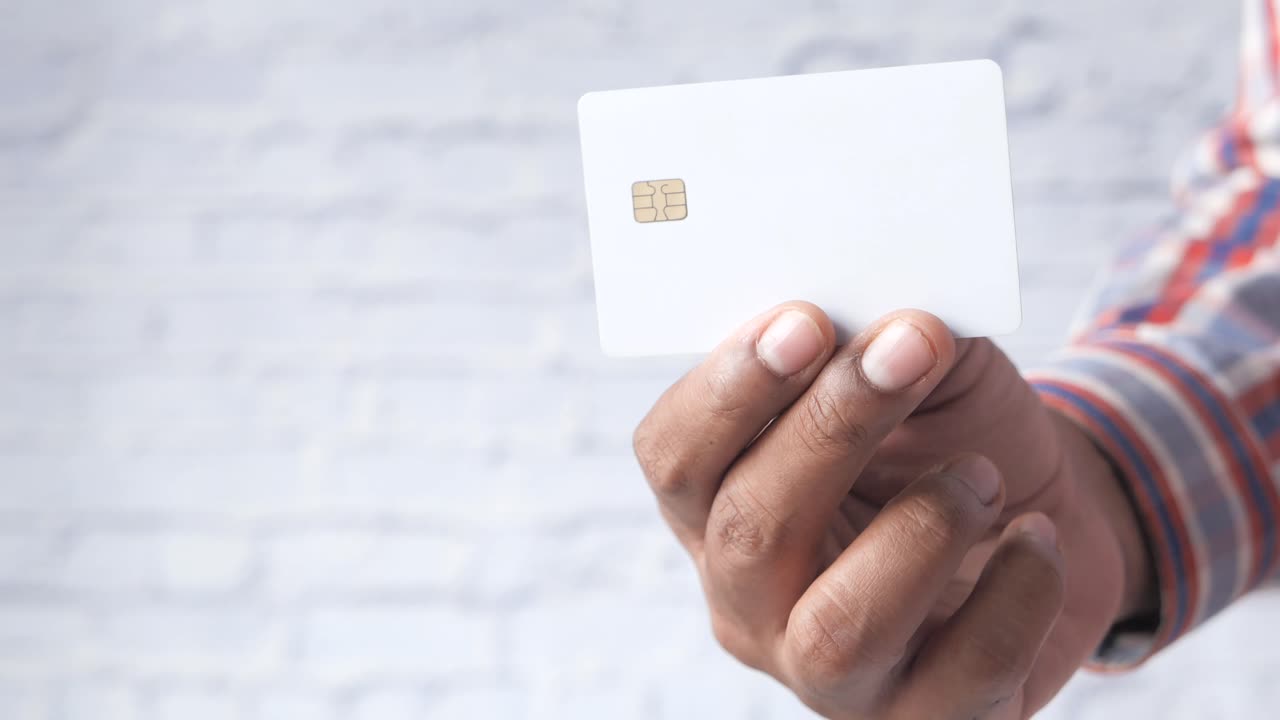 mano con una tarjeta de crédito blanca en blanco