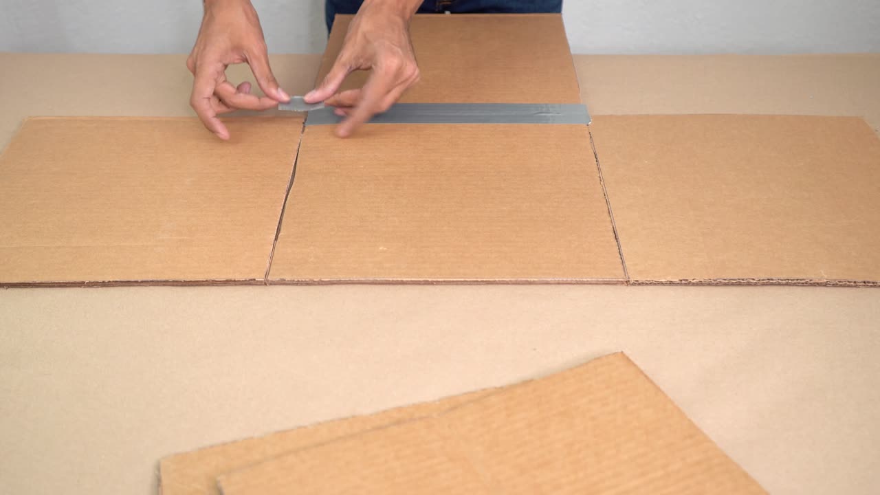 Manos creando figuras con cartón, proyecto DIY creativo y con atención al detalle