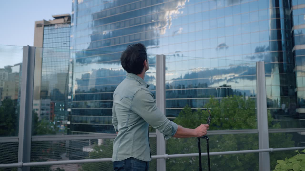 Tourist Man in $0s With Suitcase Looking Up Admiring Tall Skyscrapers in Seoul Downtown Seoullo 7017 Skygarden at Sunset - gimbal push in