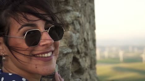 el cabello de la modelo ondeando al viento y luego girando y sonriendo a la cámara