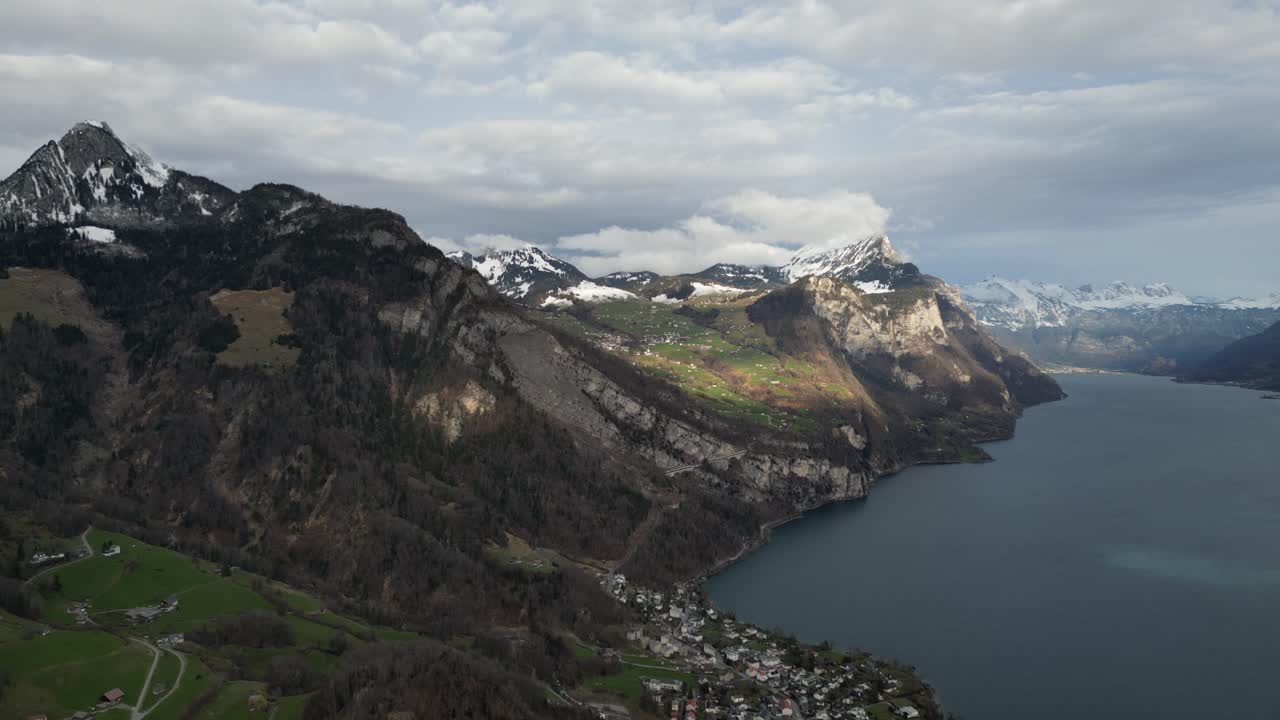 panorámica aérea estableciendo pan por encima de pendiente curvo valle y cordilleras con lago walen y sombras de nubes