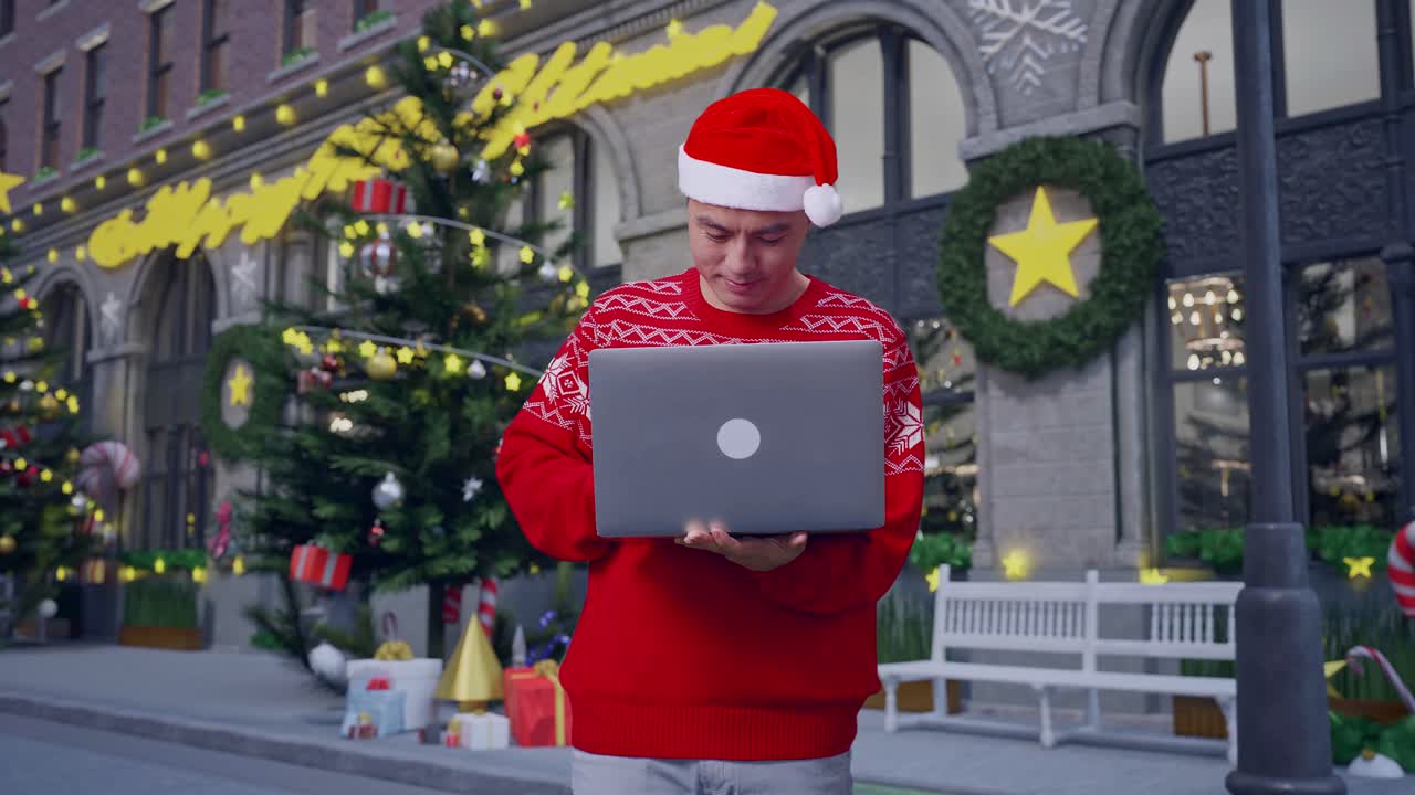 hombre asiático en traje de papá noel con una sonrisa usando una computadora portátil mientras está de pie en la noche de navidad