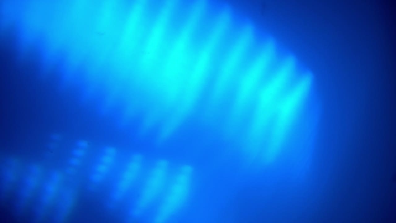 Perdite di luce blu astratte e bagliori dell'obiettivo che si muovono su sfondo scuro