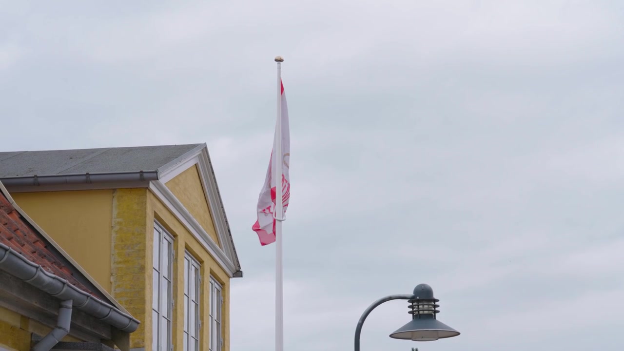 Statisk optagelse af flag i vinden nær bygning på en overskyet dag, København