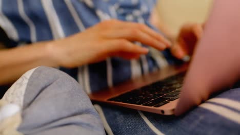 mother using laptop and her little baby lying besides her on the sofa 4k