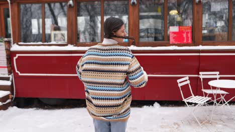 girl having fun in the snow outside a cafe