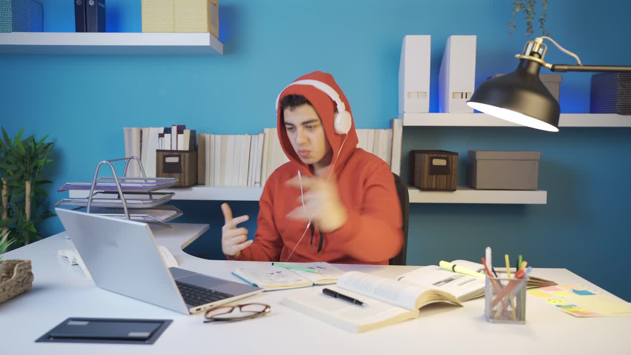 십대 남성이 반항적인 태도로 헤드폰으로 음악을 듣습니다.