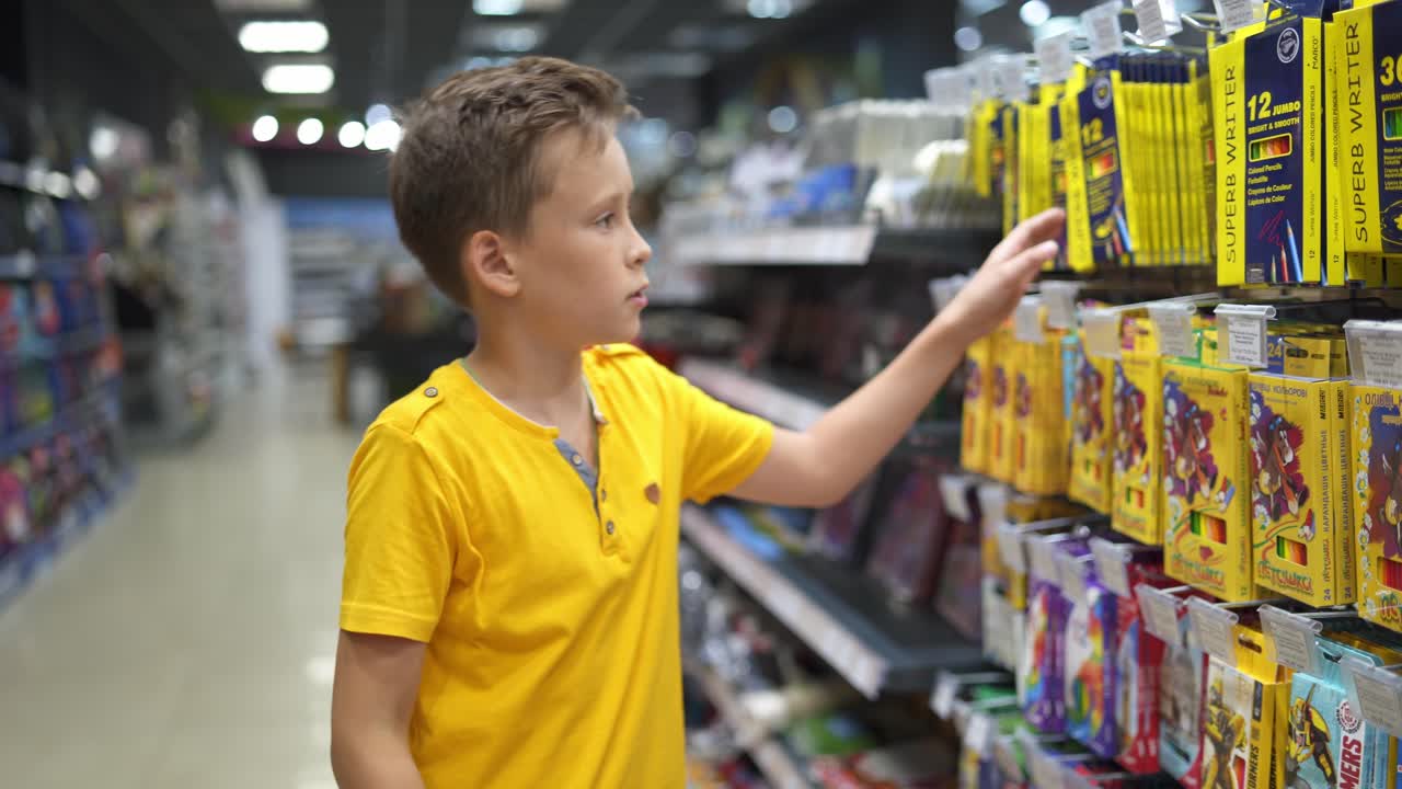 Boy shopping for back to school. Boy choosing school supplies in stationery shop