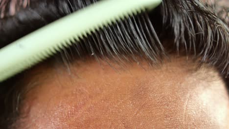 Close-up-of-young-men-comping-his-hair-with-a-brush