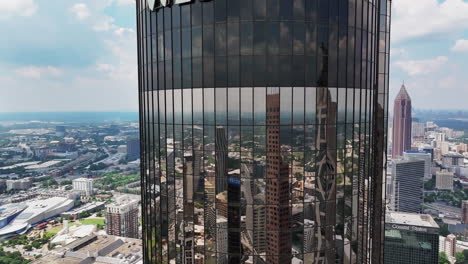 aerial ascending footage of mirror facade on futuristic high rise building in metropolis