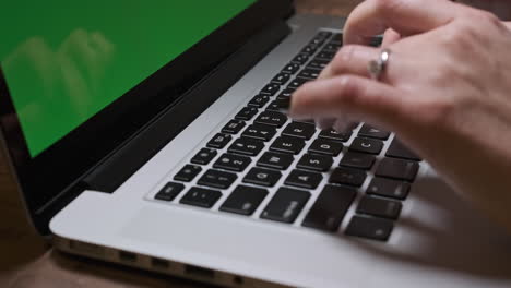 woman hands typing on laptop. green screen background