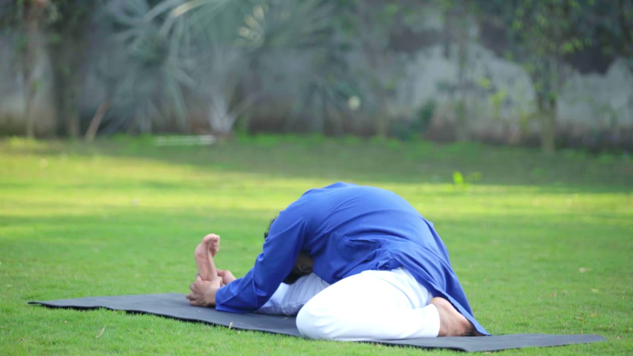 hombre indio haciendo yoga en un parque