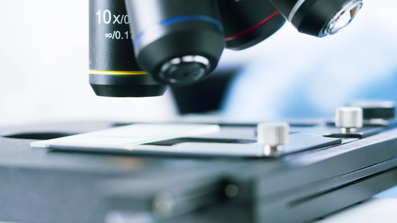 Microscope Objective Lenses Focusing on a Laboratory Slide