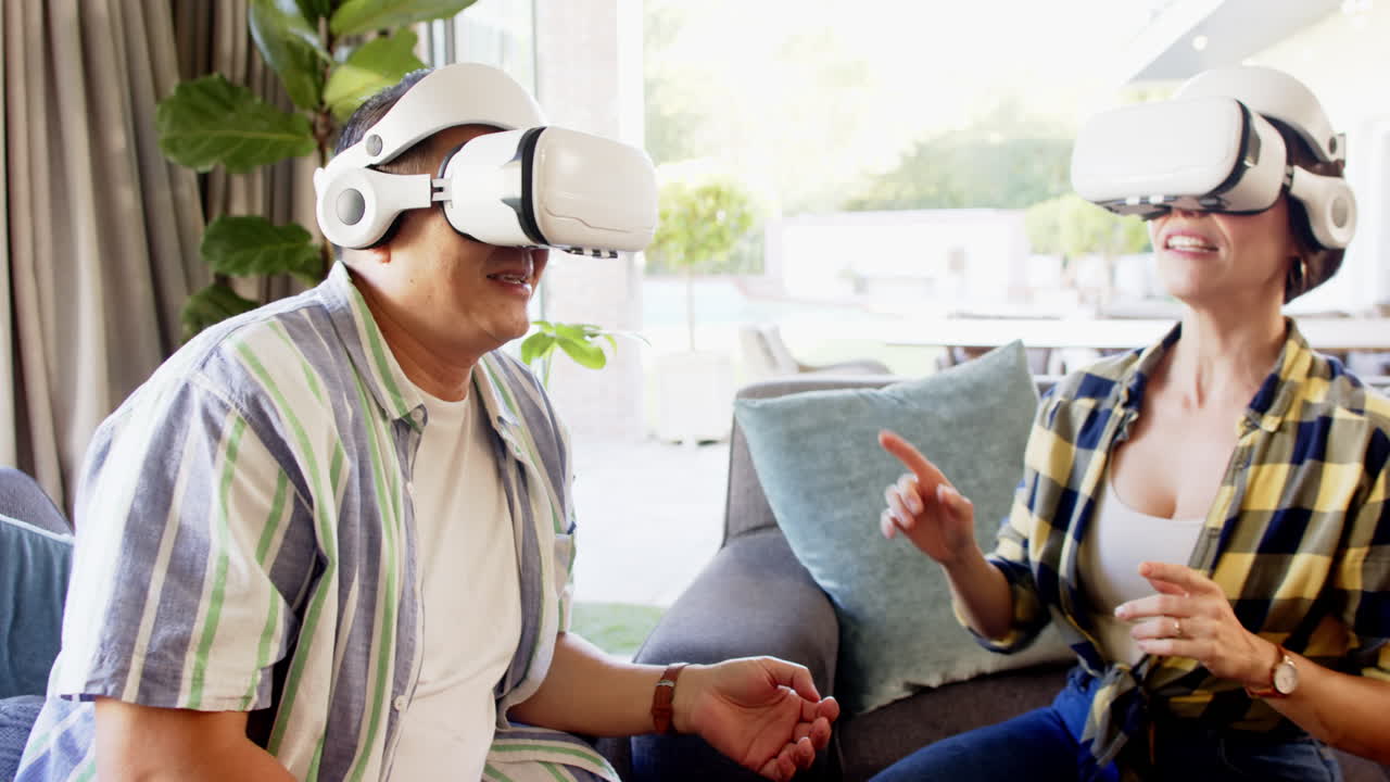 Using VR headsets, couple enjoying virtual reality experience at home