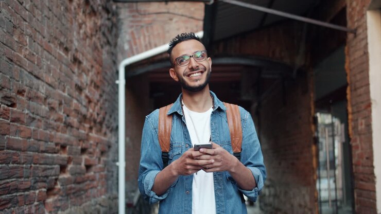 Young Man Texting on Phone in an Urban Alley