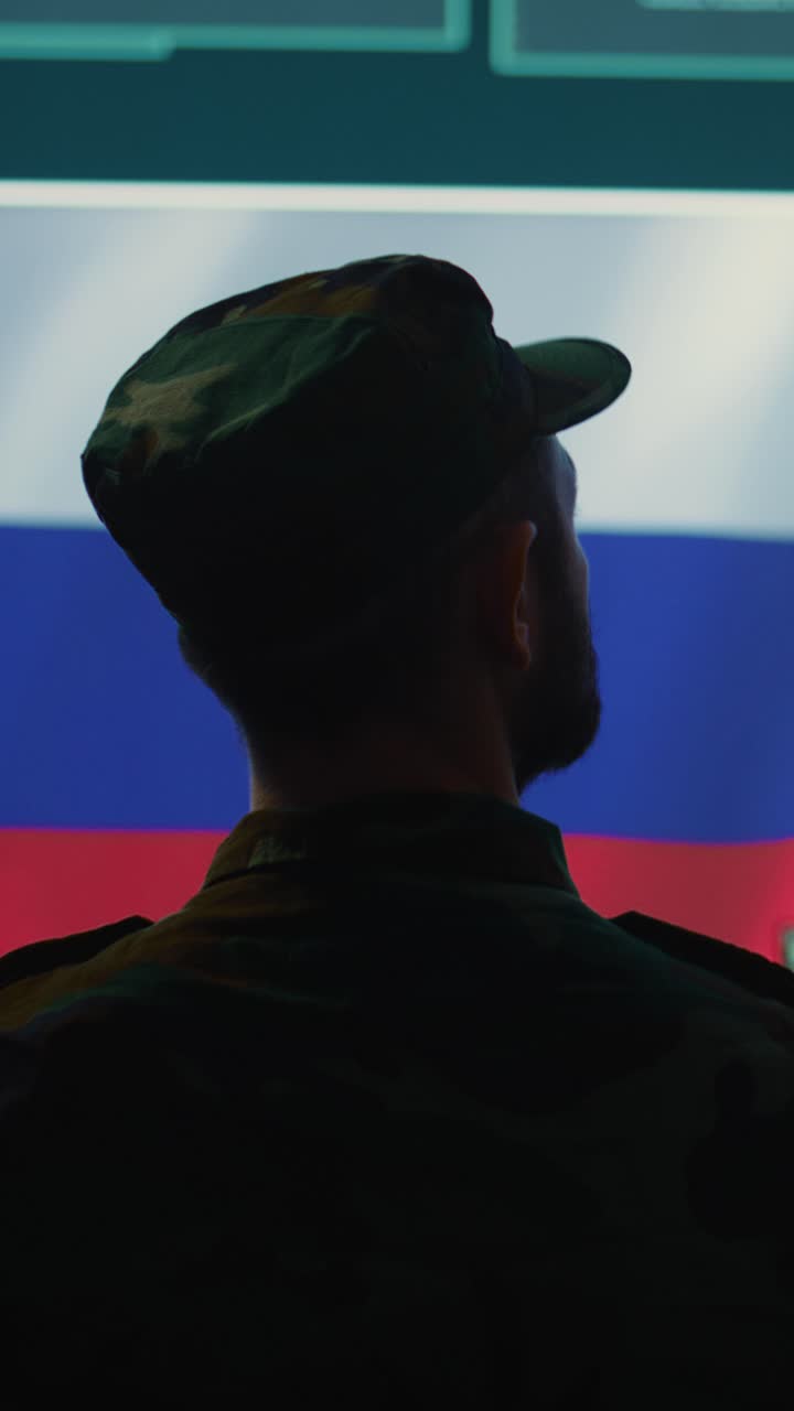 Silhouette di soldato che guarda la bandiera russa e i dati sullo schermo