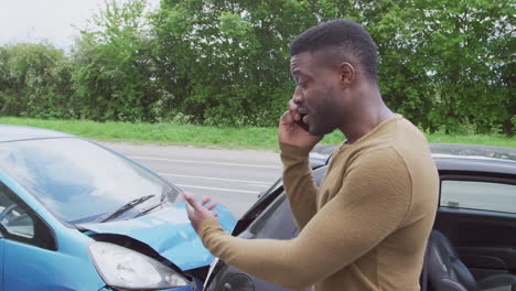 Conductor-Masculino-Involucrado-En-Accidente-Automovilístico-Llamando-A-La-Compañía-De-Seguros-Desde-La-Carretera