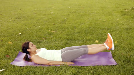 pretty brunette doing pilates in park