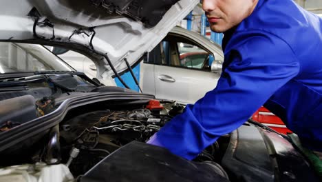 mecánico que hace el mantenimiento de un motor de coche