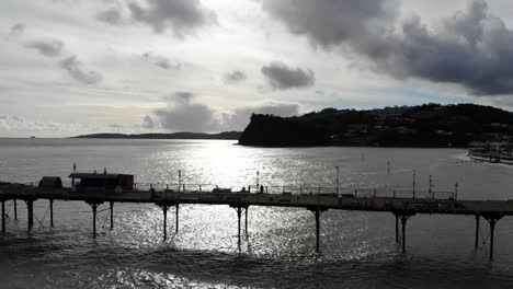 Aerial-Over-Silhouette-Of-Teignmouth's-Grand-Pier-Reaching-Out-In-The-English-Channel