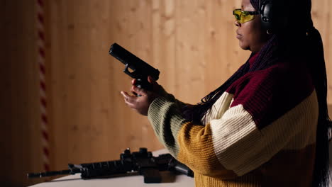 person wearing safety equipment loading bullets cartridge in pistol