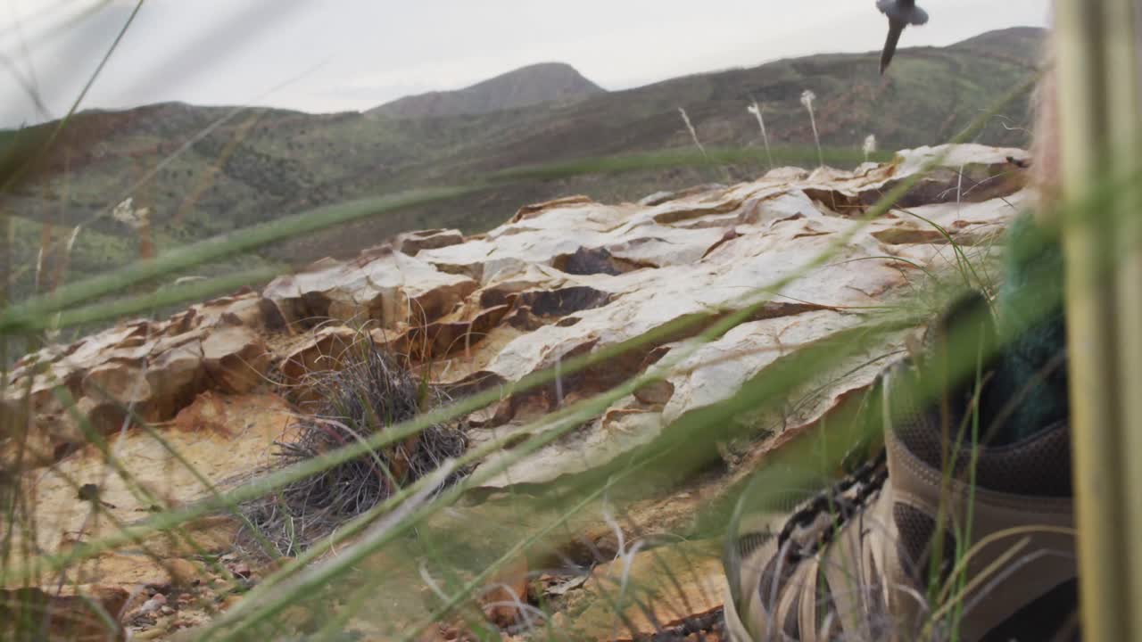 코카시안 남성 생존자의 발이 바위 산에서  ⁇ 는 막대기를 사용하여  ⁇ 고 있습니다.