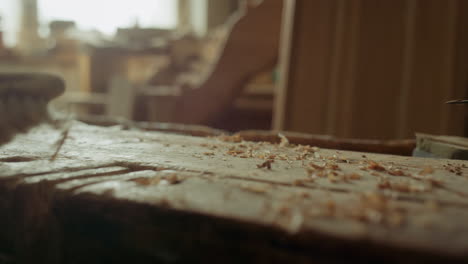 handyman cleaning wooden surface in studio