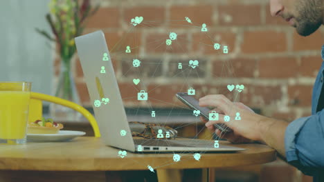 using smartphone and laptop, person seeing digital network animation at cafe