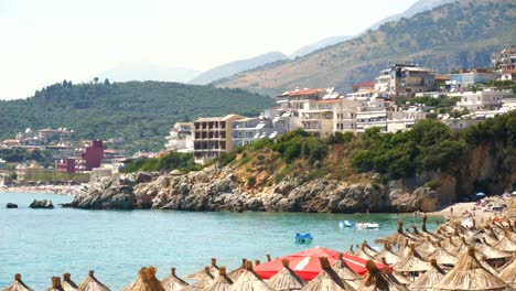 View-of-apartments,-hotels,-umbrellas,-and-sunbeds-on-the-shore-of-a-beautiful-Albanian-beach