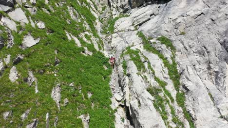 a young man is walking down hardergrat ridge during a hot and sunny day