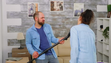 Couple-singing-and-dancing-while-cleaning-the-house