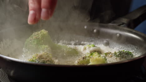 seasoning broccoli in a pan