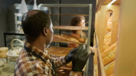 baker arranging fresh bread in a bakery