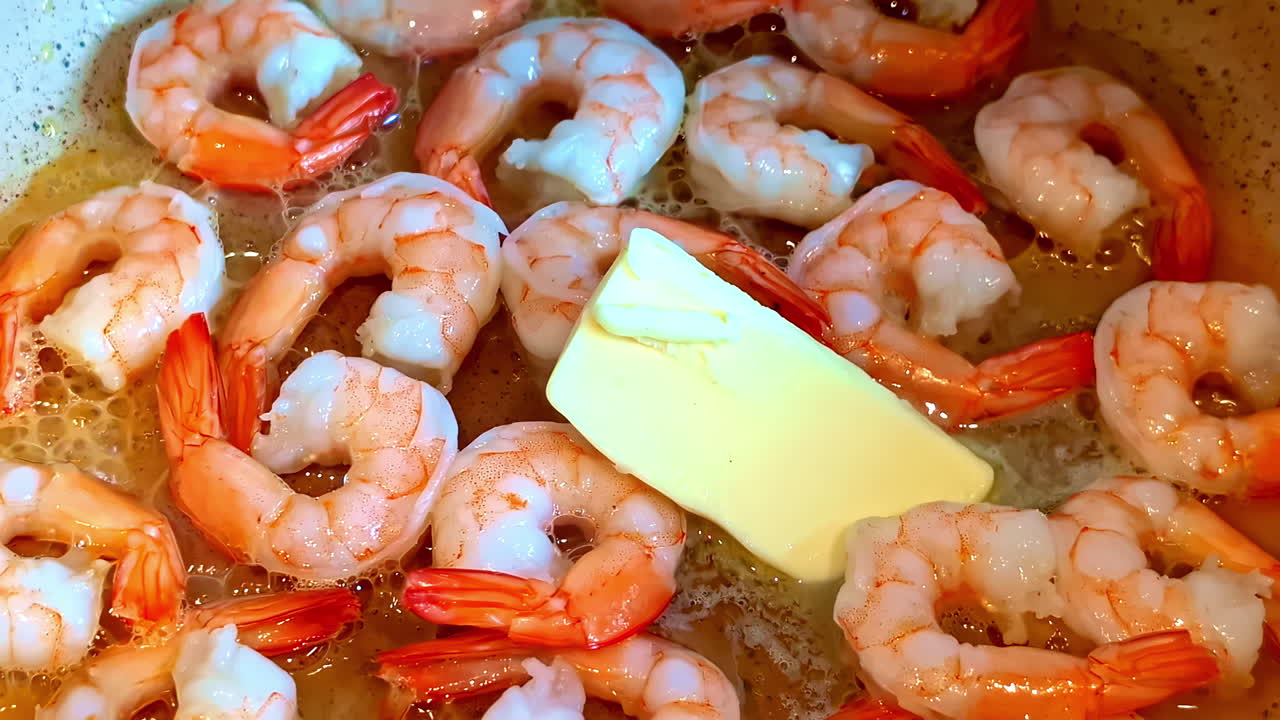 Shrimp frying in butter in hot pan close-up