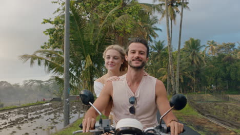 happy couple riding scooter on tropical island happy woman celebrating with arms raised enjoying romantic adventure with boyfriend on motorcycle ride in morning mist