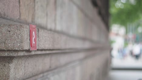 close-up of a brick wall with a red square with the number 2 on it