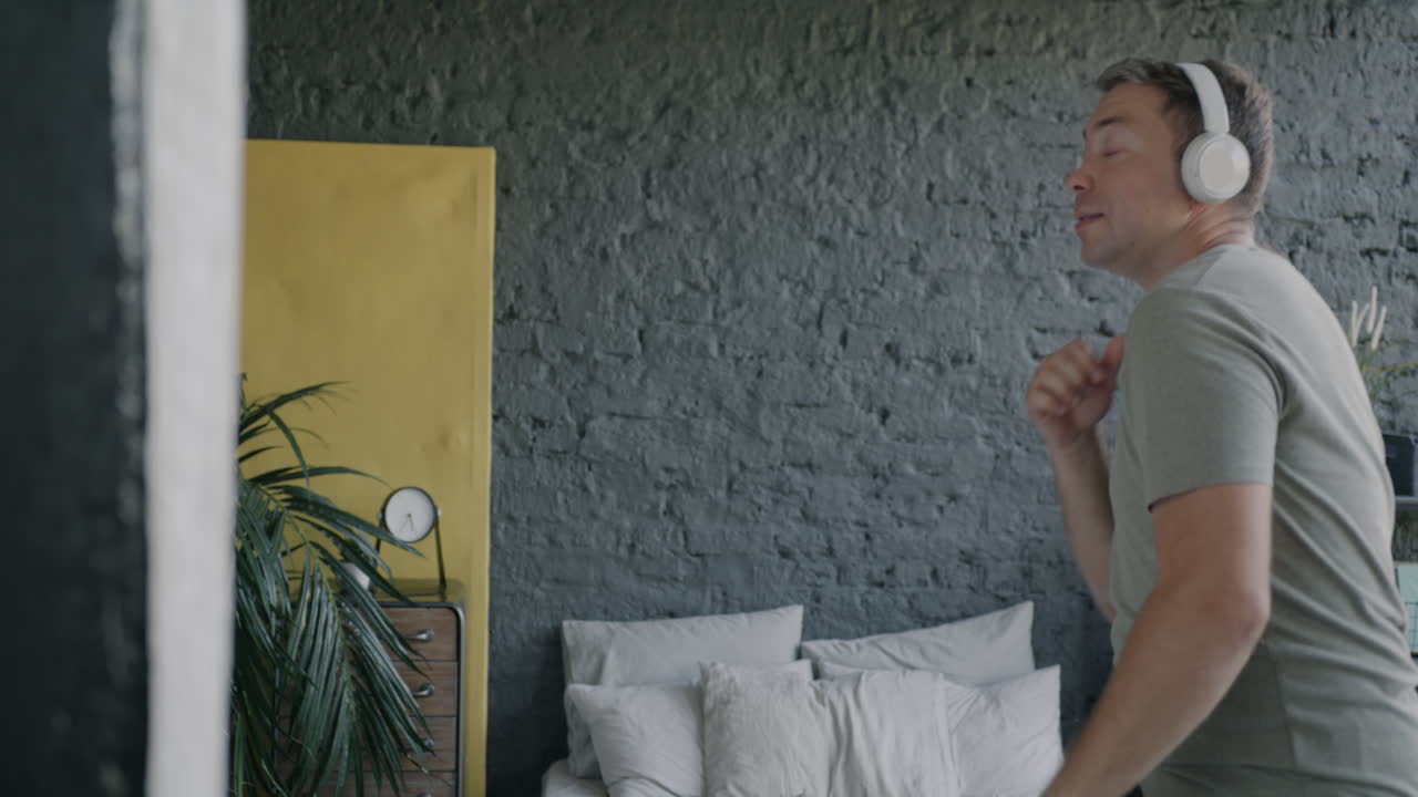 Man Dancing in Bedroom with Headphones