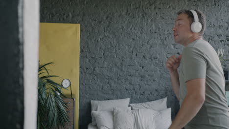 man dancing in bedroom with headphones