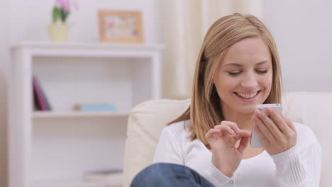 Blonde-Frau-Berührt-Ihr-Smartphone