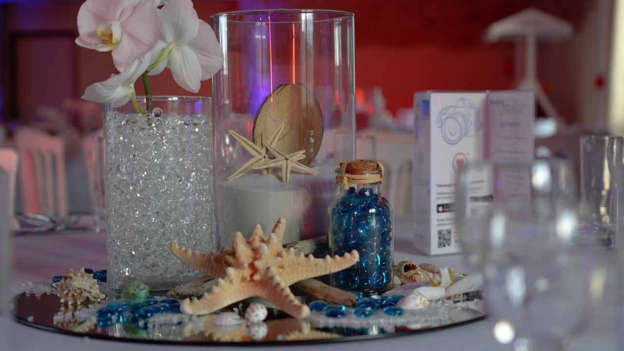 Slow motion shot of a beach inspired wedding table with glasses and plates