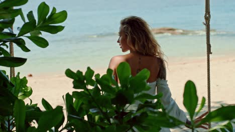 woman on a swing overlooking the beach