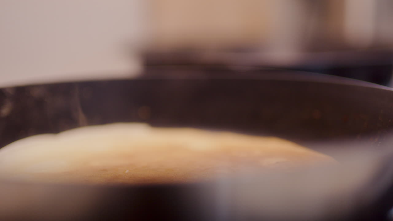 крупный план пары во время выпечки блинчиков на сковородке