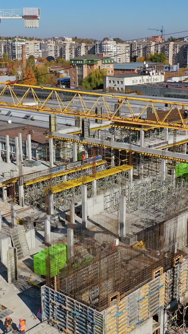 Cranes and building construction site. Vertical video