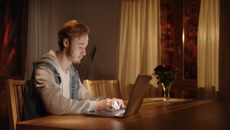 someone-is-typing-on-the-laptop-in-the-living-room,-with-light-from-outside