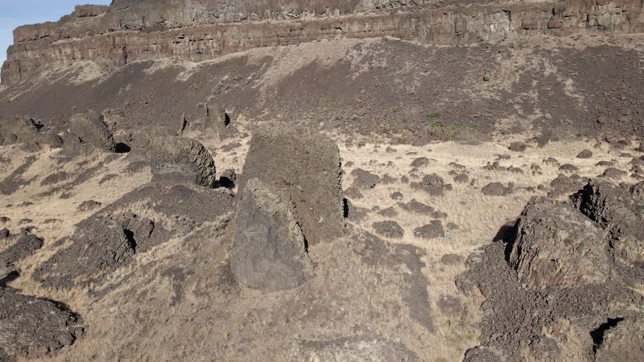 antiguas columnas de basalto erosionadas esparcidas en un cañón del desierto, cataratas secas del lago, washington, órbita aérea
