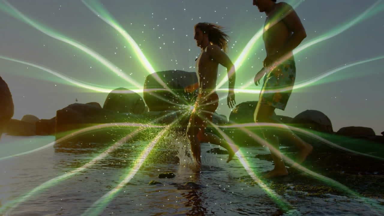 friends walking through shallow water at rocky beach, showing tech-enhanced green light rays
