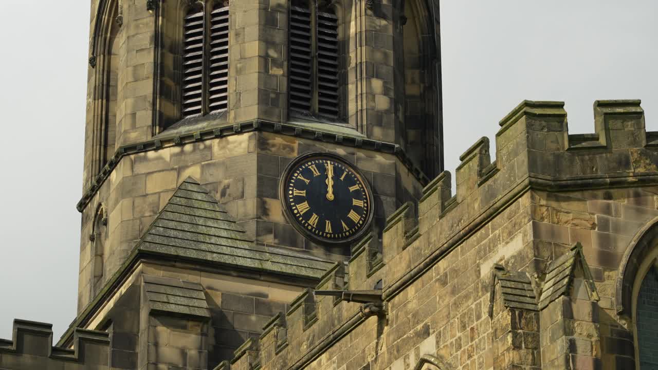 Close-up of old Anglo-Saxon church tower with clock, in Peak District countryside, England, in 4K, 60fps