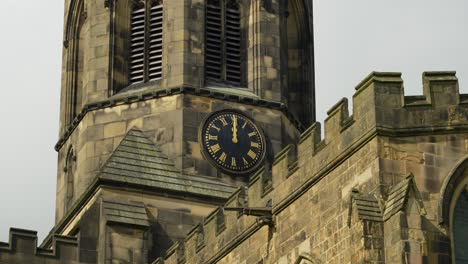 Close-up-of-old-Anglo-Saxon-church-tower-with-clock,-in-Peak-District-countryside,-England,-in-4K,-60fps