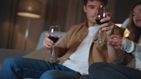 loving boyfriend taking wine glasses from table with lying red roses close up.